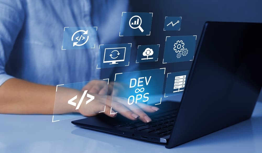 A glowing interface of DevOps tools and concepts hover above a laptop.