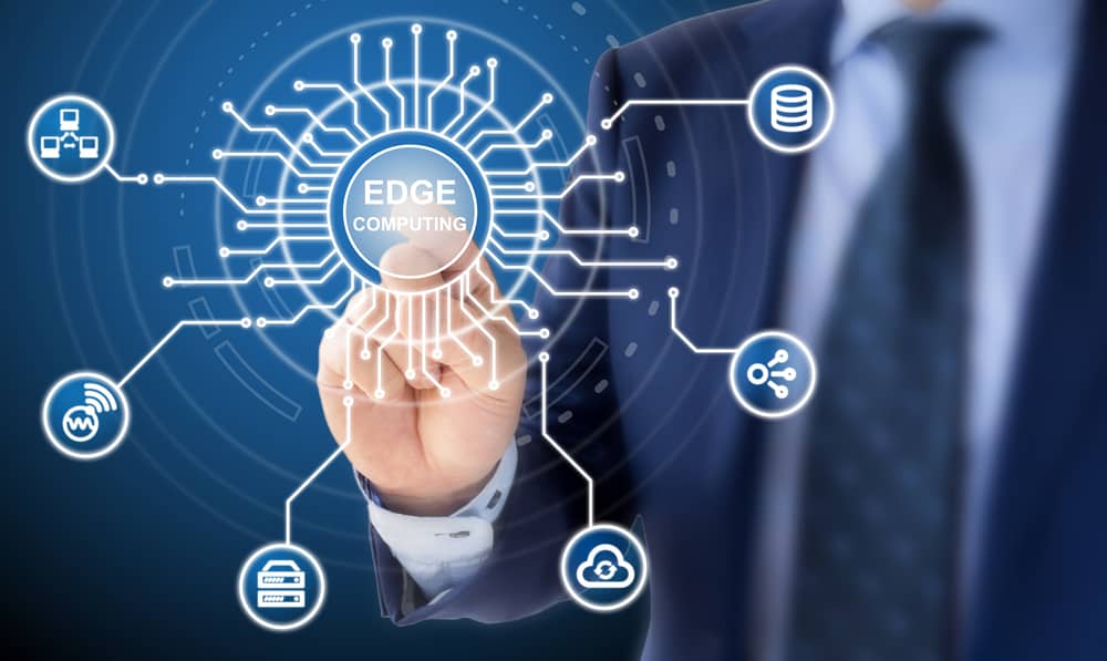 A person in a suit taps a glowing edge computing ecosystem with many network connections and glowing icons of edge computing concepts