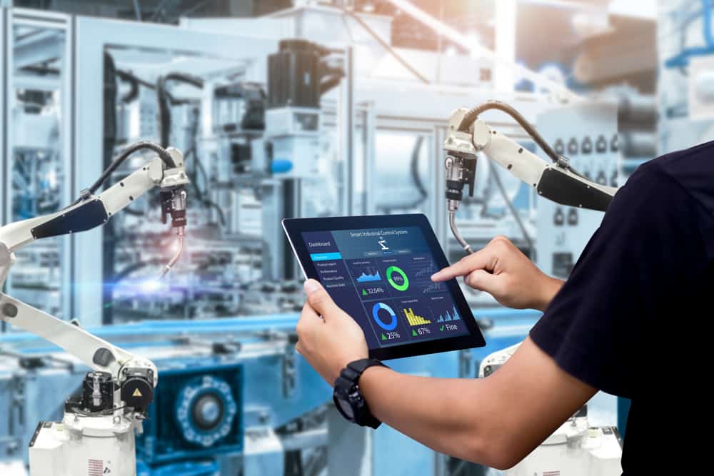 An engineer using a tablet to control robotic machinery illustrates a use case for operational technology security An engineer using a tablet to control robotic machinery illustrates a use case for operational technology security